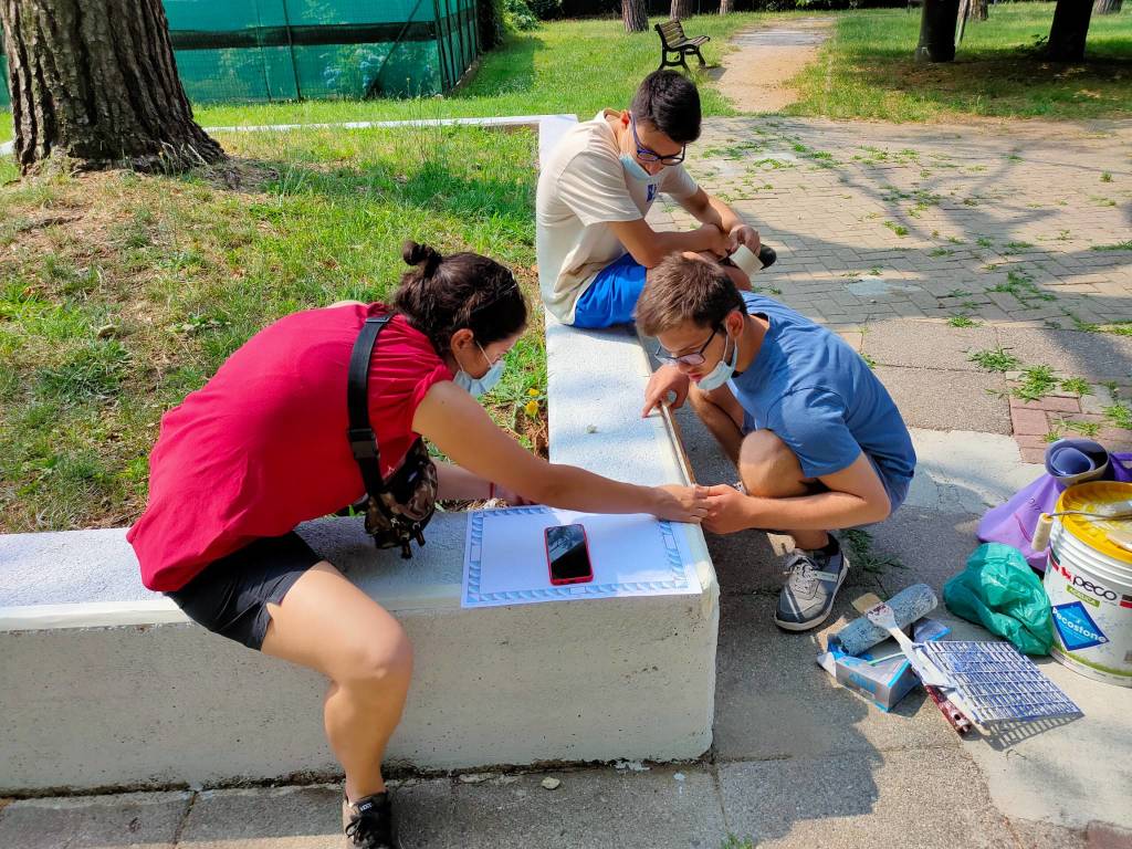 Giovani saronnesi al lavoro per dipingere le panchine del Matteotti 