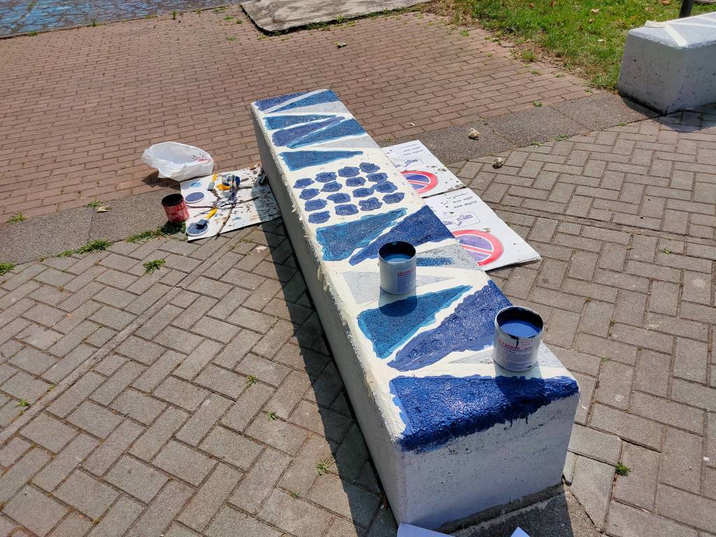 Giovani saronnesi al lavoro per dipingere le panchine del Matteotti 