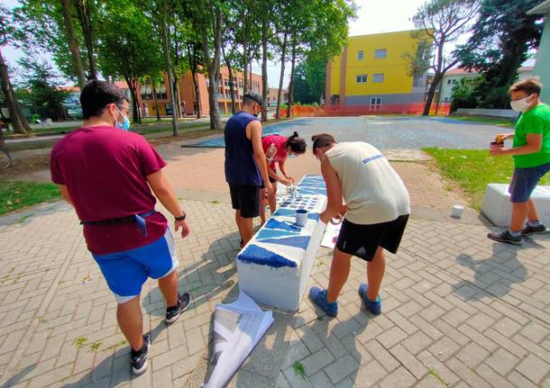 Giovani saronnesi al lavoro per dipingere le panchine del Matteotti 